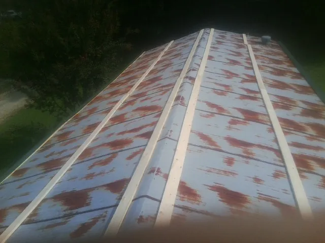 Rusted metal roof panels with new wood purlins before replacement — Storm Damage Roof Repair in Arden by Roofing Brothers
