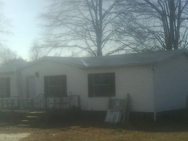 New metal roof on a white painted brick home on a foggy morning in Arden